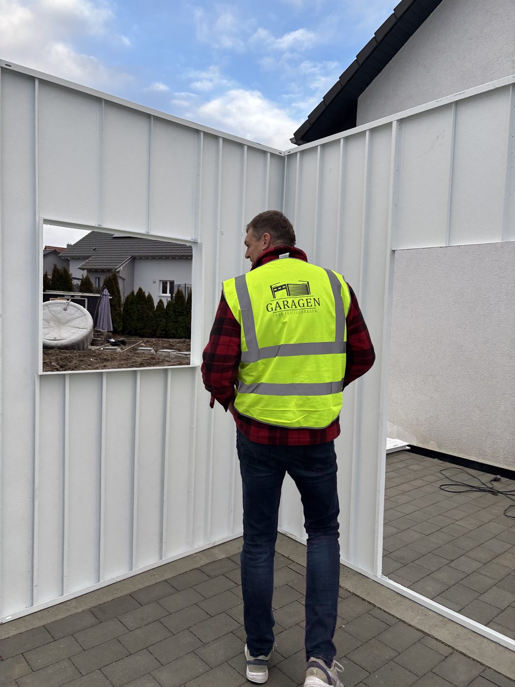 FF-Garagen-Monteur beim Aufstellen eines Wandelements der Stahlgarage