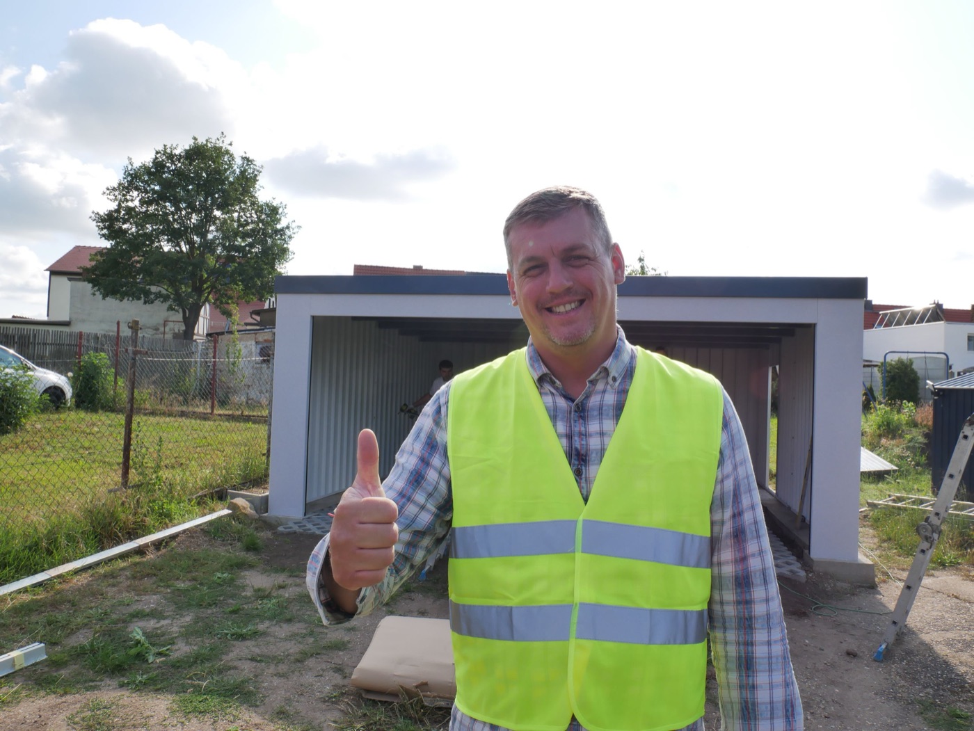 Roman Fast, Inhaber und Gründer von FF Garagen, auf einer Baustelle vor einer fertigen Stahlgarage